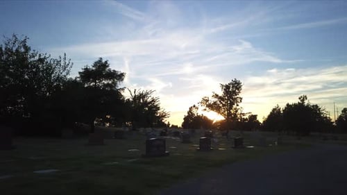Low aerial shot through a graveyard during sunset