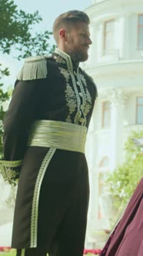 Man in Regal Suit Outside Palace Awaits