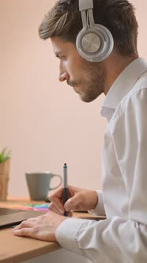 Focused Man Photo Editor Processes Photos on a Laptop at Home Freelance Editor Working on a Graphics