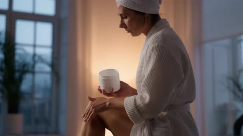 Woman Applying Cream in Bathroom after Luxurious Bubble Bath