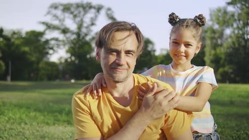 Father and Daughter Embracing in a Sunny Park