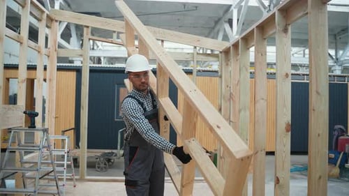 Construction Worker Carrying Wood in Building