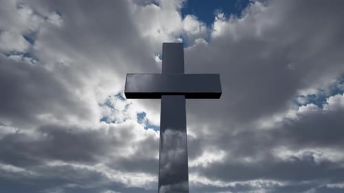 Reflective Cross with Moving Clouds Revealing Blue Sky