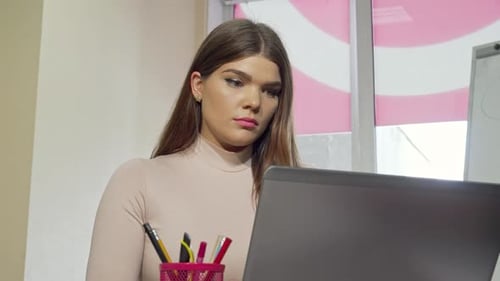 Exhausted Female Student Stressed While Working on a Laptop