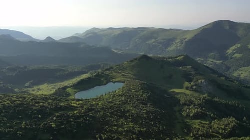 A beautiful alpine lake surrounded by mountains and a beautiful forest. Aerial view.