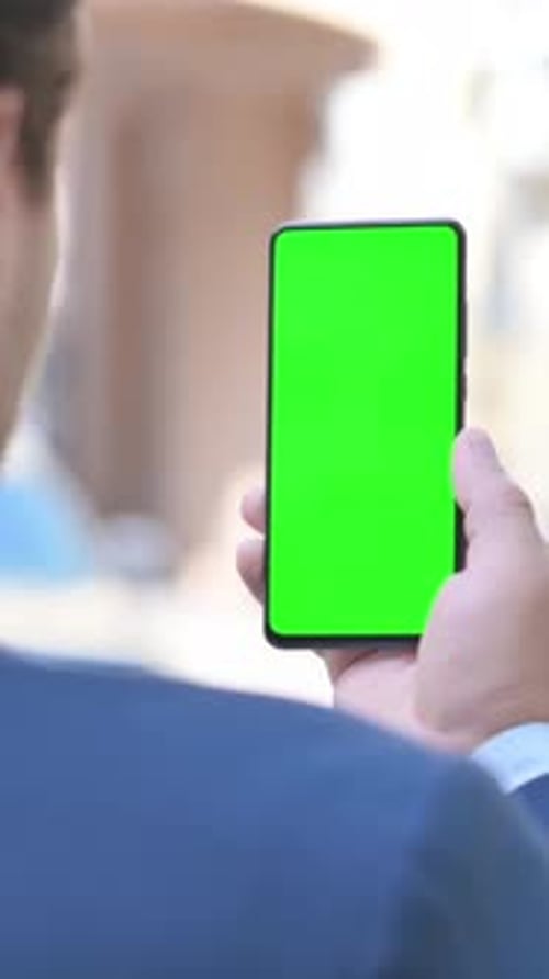 Businessman Using Phone with Green Screen Outdoor, vertical