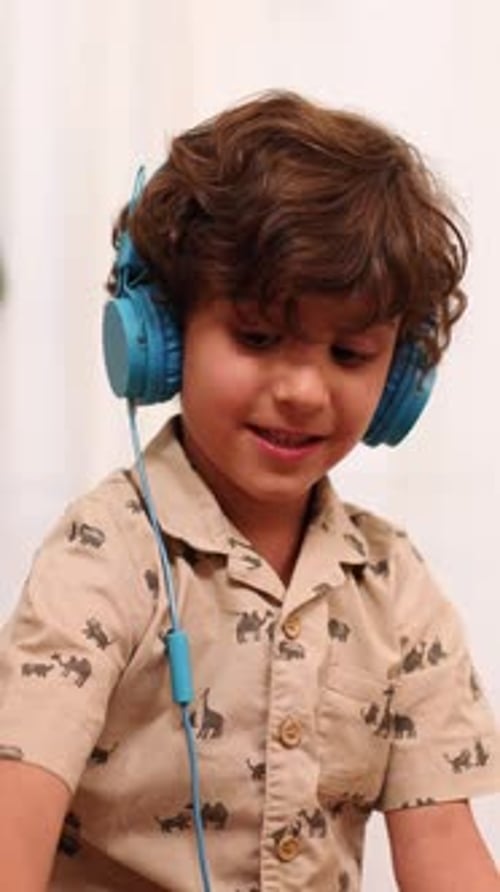 Boy with Headphones Listening to Audio Indoors