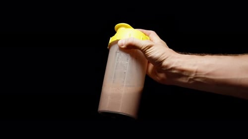 Hand Shaking Protein Drink in Plastic Bottle
