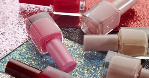 Close-up of Assorted Nail Polish on Glittery Surface
