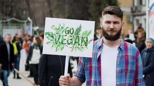 Un végétarien tient une bannière végétalienne lors d'une manifestation de véganisme pour les droits des animaux