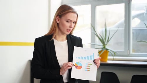 Woman Presenting Data Charts to Office Colleagues