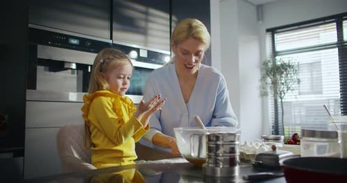 Camera View of Happy Caucasian Mother and Her Cute Daughter Blowing Flour From Their Palms Family