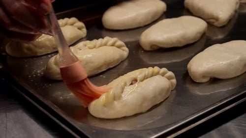 Closeup View of Raw Handmade Stuffed Pastry Pockets Arranged on a Metal Baking Tray Showcasing