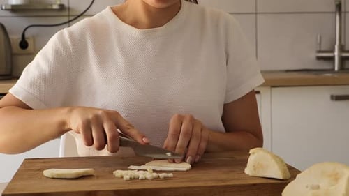 Woman Dicing Celery Root on Cutting Board