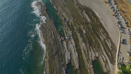 Aerial View Sunset on a Rocky Mediterranean Beach Waves Crashing on the Shore