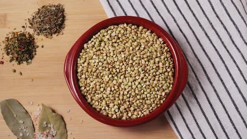 On a Wooden Table There is a Bowl of Green Buckwheat with Aromatic Spices and Bay Leaf the Concept