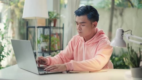 Young Adult Working at Laptop in Bright Home