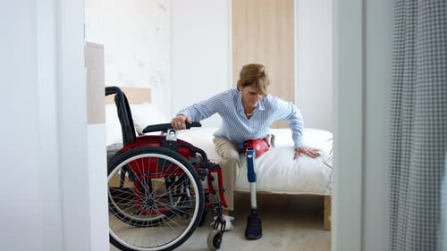 Disabled Mature Woman Getting Up From Bed Indoors at Home Leg Prosthetic