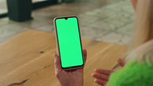 Woman Holding Smartphone with Green Screen Display
