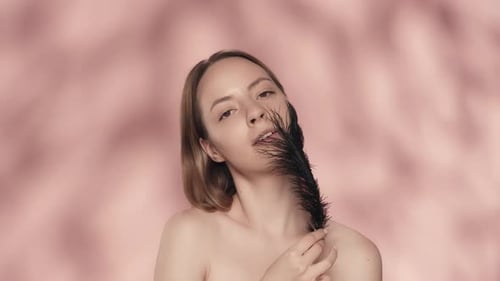 Attractive Young Woman Shows Off Smooth and Soft Skin While Touching Her Face and Naked Shoulders