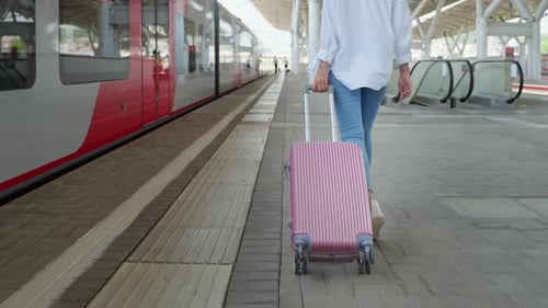 Young Woman with Suitcase is Walking on Railway Platform Rear View on Bottom Body Part Follow Shot