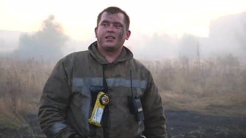 Brave Firefighter Stands Near Smoke and Fire