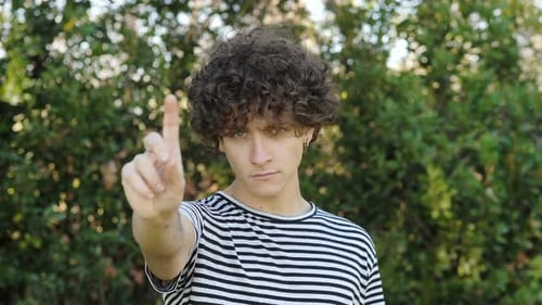 Young Adult Says No with Finger Gesture