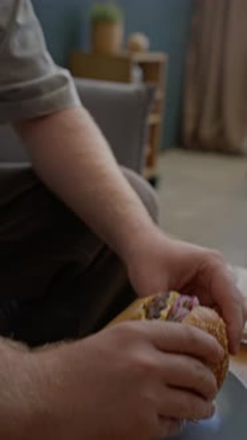 Young Man Eating Burger at Home