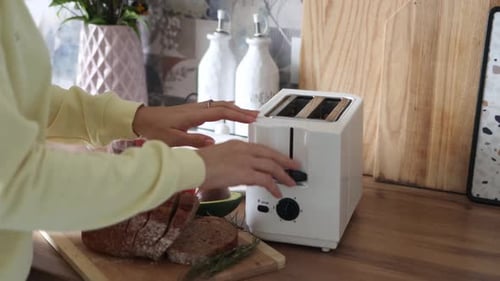 Woman Toasting Bread for Breakfast at Home