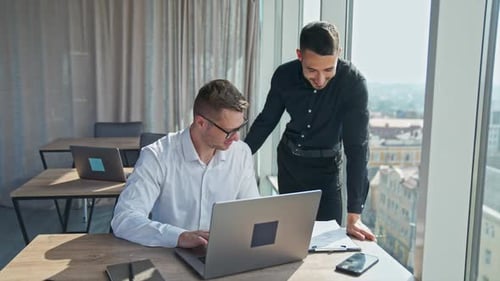 Businessmen Discussing Project on Laptop in Office