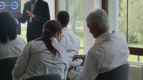 Medical Professionals Reviewing Data During a Presentation