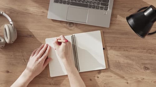 Female Hands Write with Pen Phrase LESSON 1 in Notebook Top Down View on Desktop