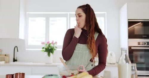 Woman stirring batter in kitchen
