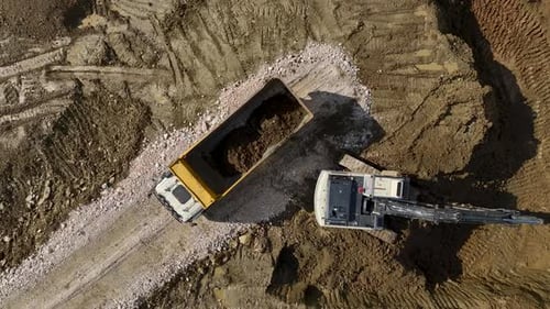 Excavator Loading Soil into Dump Truck, Aerial View
