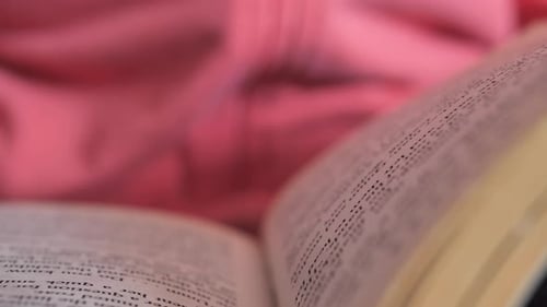 Young woman reading book, closeup hands and pages. Leafing through the pages.