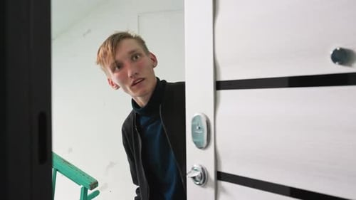 Young Man Receiving Package at Apartment Doorway