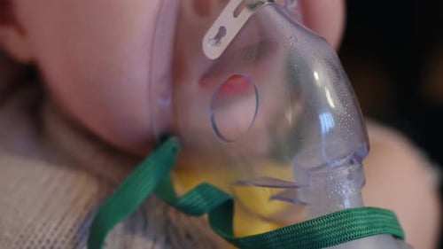 Close up of steam inhalation for an infant newborn baby, breathing through mask