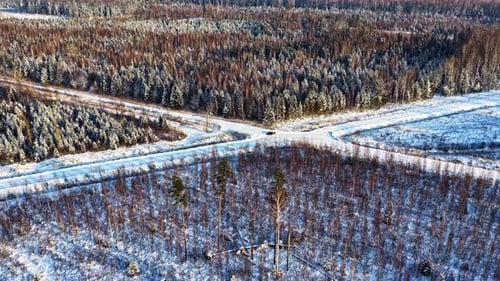 Aerial view of a snowy forest intersection with roads in the winter