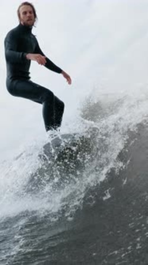Young Adult Surfing on a Wave with Wetsuit