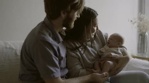 Loving Parents Hold Newborn Infant Tenderly at Home
