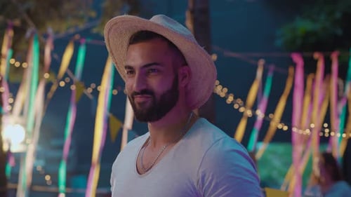 Smiling Man with Beard and Hat at Party