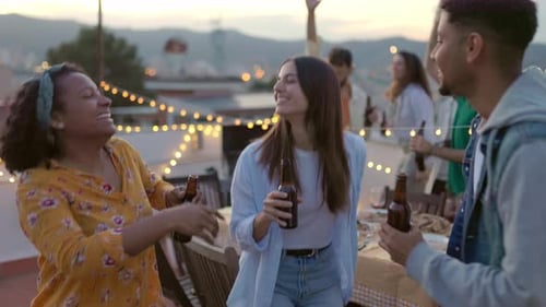 Friends Enjoying a Rooftop Party with String Lights