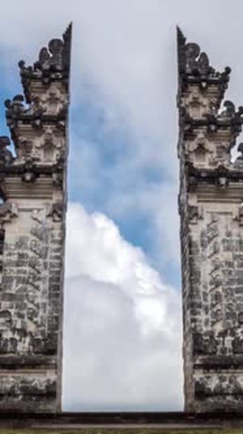 Porte d'entrée d'un ancien temple en pierre avec piliers sculptés et ciel Théâtral au-dessus des ruines
