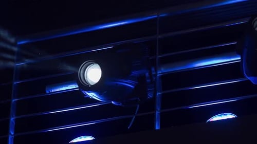 Scheinwerfer mit beweglichem Kopf, die Lichtstrahlen in eine dunkle Umgebung projizieren