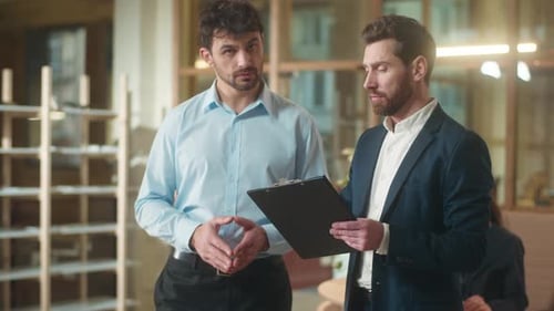 Business Partners Men Caucasian Businessmen Talk Discuss Documents Contract in Office Professional