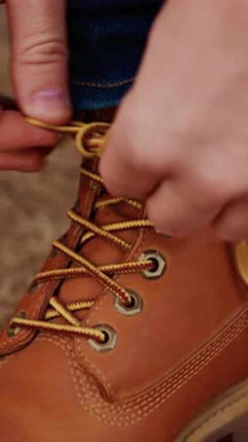 Man Tying the Laces of a Leather Boot