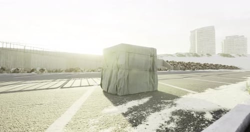 A Large Wrapped Package Sits Alone on an Empty Sunny Road