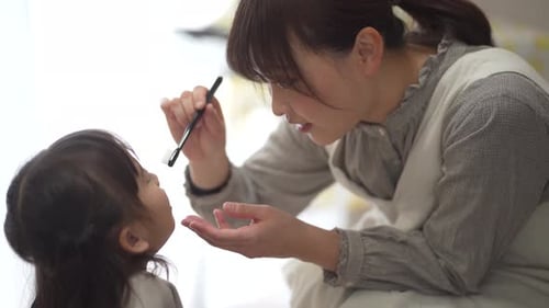 Mother Helping Child Brush Teeth Indoors