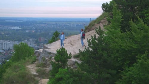 Young Couple on Scenic Hilltop Overlooking Distant City