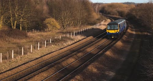 Un tren de pasajeros de un solo vagón que pasa por una pasarela peatonal